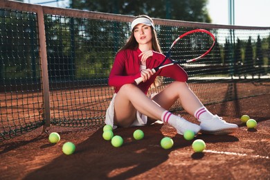 Photo of Beautiful woman with racket and balls at tennis court