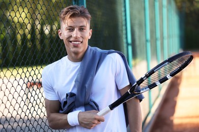 Photo of Young man with racket at tennis court