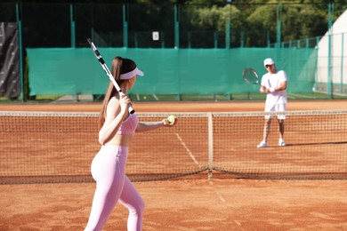Photo of Woman and man playing tennis at court
