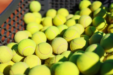 Photo of Many tennis balls in cart outdoors, closeup