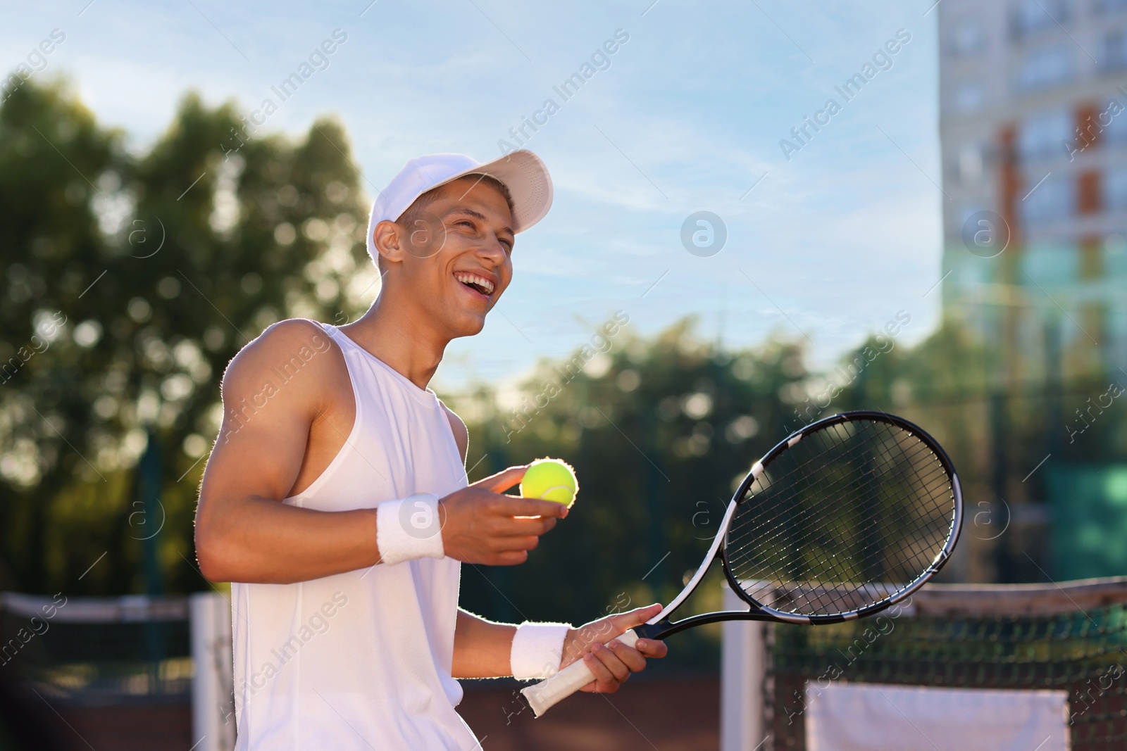 Young man playing tennis at court on sunny day Photo of Young man playing tennis at court on sunny day