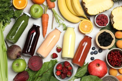 Photo of Superfood. Bottles with healthy drinks and ingredients on light wooden table, flat lay