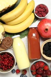 Photo of Superfood. Bottles with tasty smoothies and ingredients on light wooden table, flat lay
