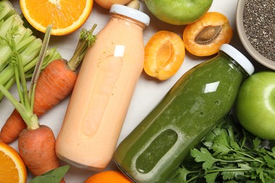 Photo of Superfood. Bottles with tasty smoothies and ingredients on light wooden table, flat lay