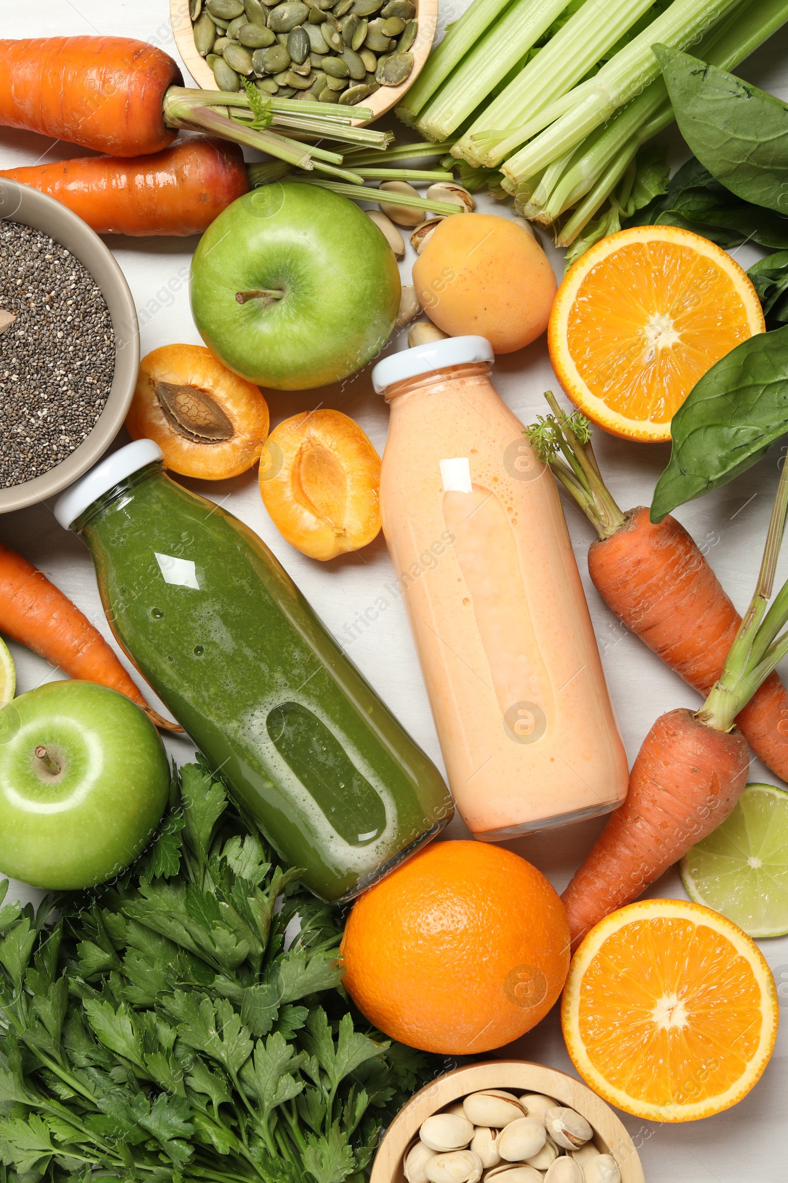 Superfood. Bottles with tasty smoothies and ingredients on light wooden table, flat lay Photo of Superfood. Bottles with tasty smoothies and ingredients on light wooden table, flat lay