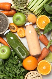 Photo of Superfood. Bottles with tasty smoothies and ingredients on light wooden table, flat lay