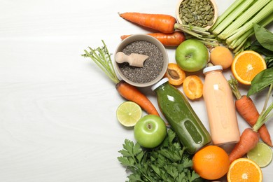 Photo of Superfood. Bottles with tasty smoothies and ingredients on light wooden table, flat lay. Space for text