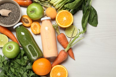 Photo of Superfood. Bottles with tasty smoothies and ingredients on light wooden table, flat lay