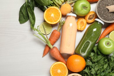 Photo of Superfood. Bottles with tasty smoothies and ingredients on light wooden table, flat lay