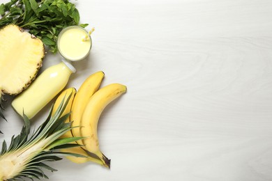 Photo of Superfood. Tasty smoothie and ingredients on light wooden table, flat lay. Space for text