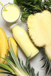 Photo of Superfood. Tasty smoothie and ingredients on light wooden table, flat lay