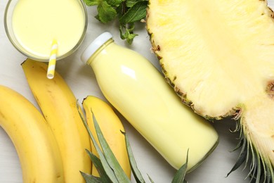 Photo of Superfood. Tasty smoothie and ingredients on light wooden table, flat lay