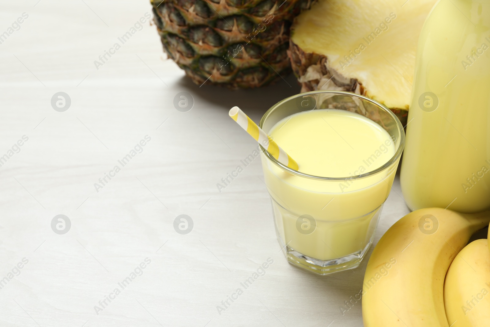 Superfood. Tasty smoothie in glass and ingredients on light wooden table, closeup. Space for text Photo of Superfood. Tasty smoothie in glass and ingredients on light wooden table, closeup. Space for text