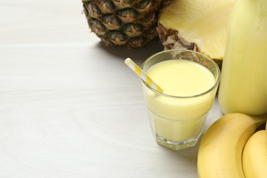 Photo of Superfood. Tasty smoothie in glass and ingredients on light wooden table, closeup. Space for text