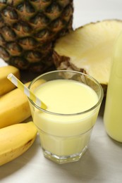 Photo of Superfood. Tasty smoothie in glass and ingredients on light wooden table, closeup