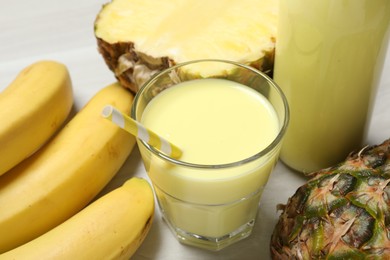 Photo of Superfood. Tasty smoothie in glass and ingredients on light wooden table, closeup