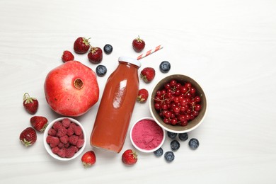 Photo of Superfood. Tasty smoothie in bottle and ingredients on light wooden table, flat lay