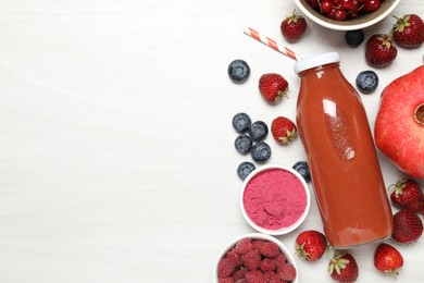 Photo of Superfood. Tasty smoothie in bottle and ingredients on light wooden table, flat lay. Space for text
