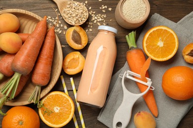 Photo of Superfood. Tasty smoothie in bottle and ingredients on wooden table, flat lay
