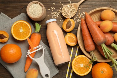 Photo of Superfood. Tasty smoothie in bottle and ingredients on wooden table, flat lay