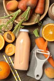 Photo of Superfood. Tasty smoothie in bottle and ingredients on wooden table, flat lay