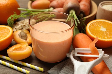 Photo of Superfood. Tasty smoothie in glass and ingredients on wooden table, closeup