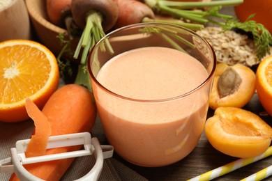 Photo of Superfood. Tasty smoothie in glass and ingredients on wooden table, closeup