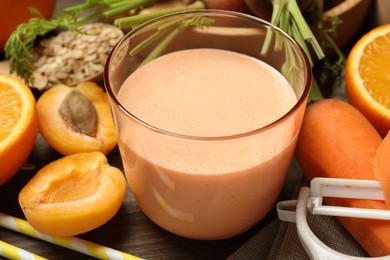 Photo of Superfood. Tasty smoothie in glass and ingredients on wooden table, closeup
