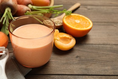 Photo of Superfood. Tasty smoothie in glass and ingredients on wooden table, closeup