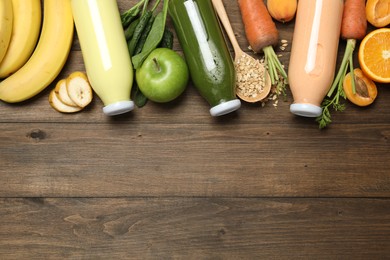 Photo of Superfood. Tasty smoothies in bottles and ingredients on wooden table, flat lay. Space for text