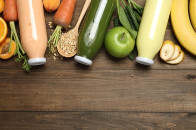 Photo of Superfood. Tasty smoothies in bottles and ingredients on wooden table, flat lay. Space for text