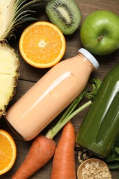 Photo of Superfood. Tasty smoothies in bottles and ingredients on wooden table, flat lay
