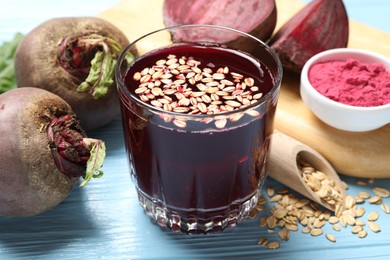Photo of Superfood. Tasty juice with oats in glass and beetroots on light blue wooden table, closeup