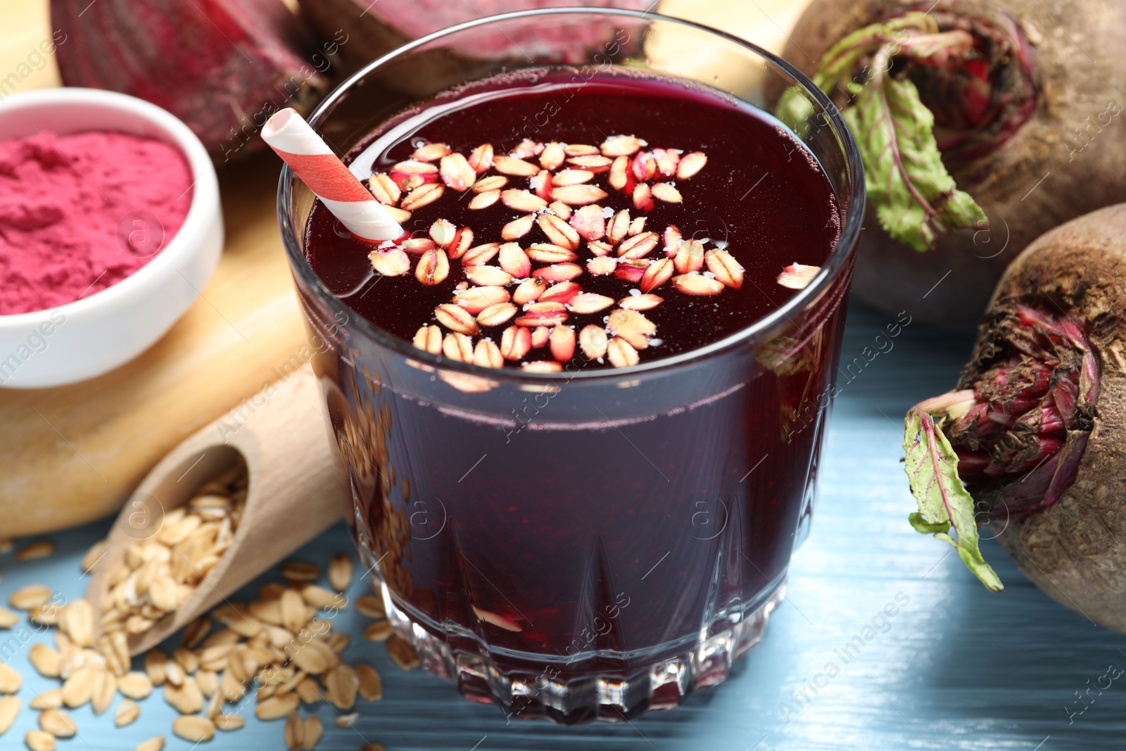 Superfood. Tasty juice with oats in glass and beetroots on light blue wooden table, closeup Photo of Superfood. Tasty juice with oats in glass and beetroots on light blue wooden table, closeup