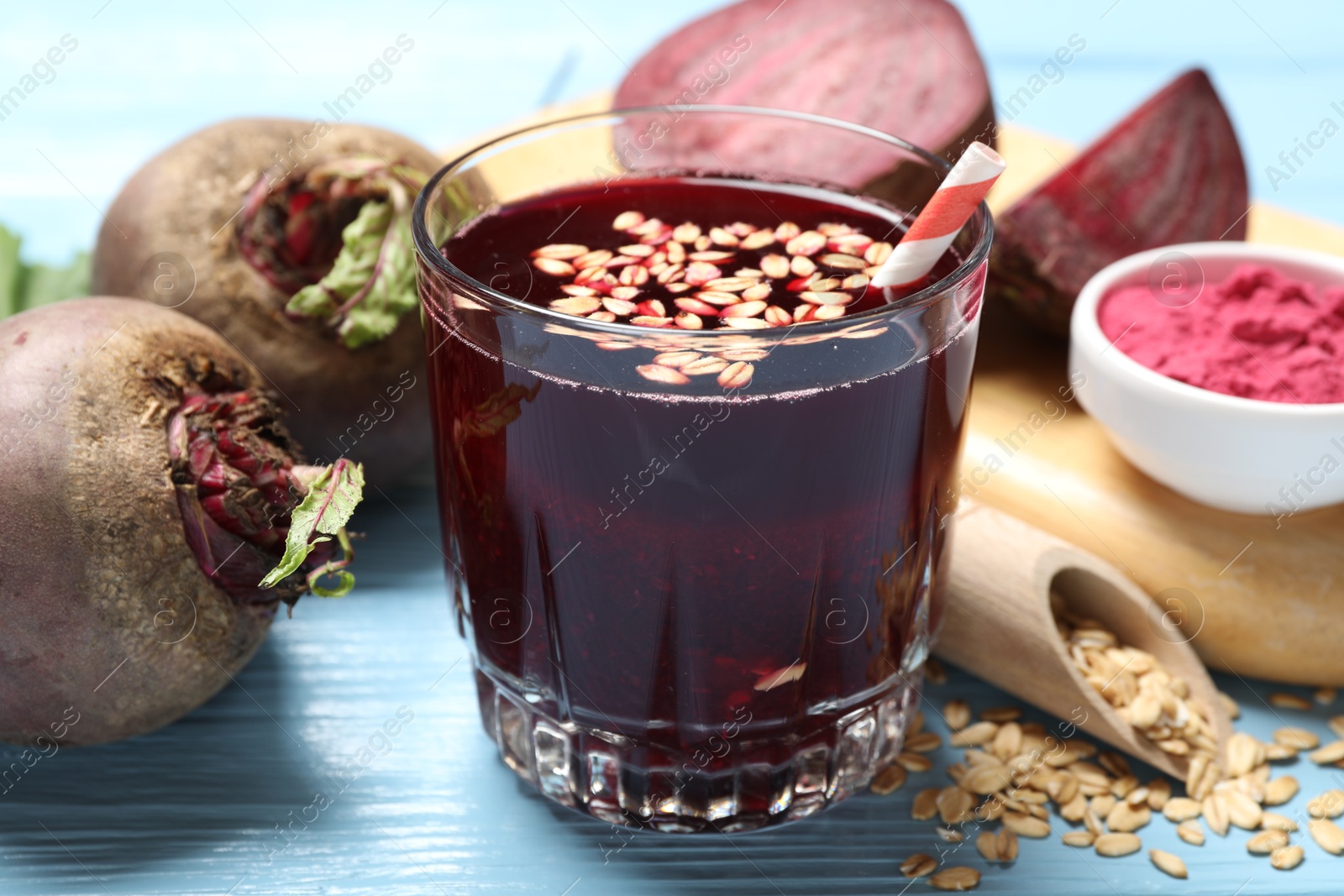 Superfood. Tasty juice with oats in glass and beetroots on light blue wooden table, closeup Photo of Superfood. Tasty juice with oats in glass and beetroots on light blue wooden table, closeup