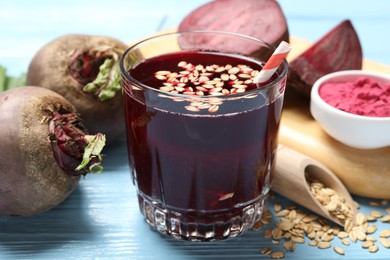 Photo of Superfood. Tasty juice with oats in glass and beetroots on light blue wooden table, closeup