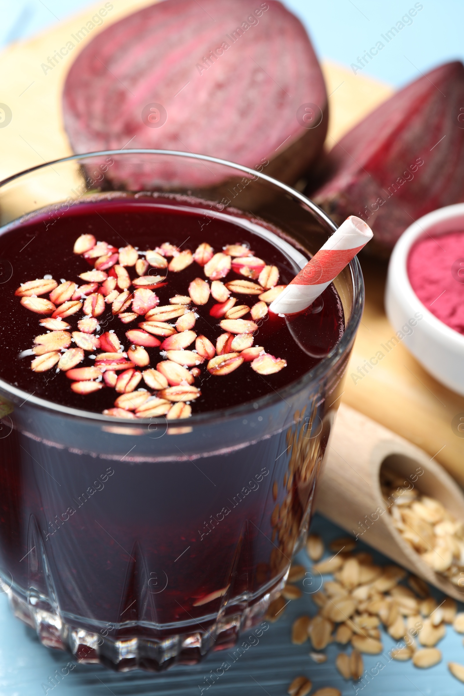 Superfood. Tasty juice with oats in glass and beetroots on light blue wooden table, closeup Photo of Superfood. Tasty juice with oats in glass and beetroots on light blue wooden table, closeup