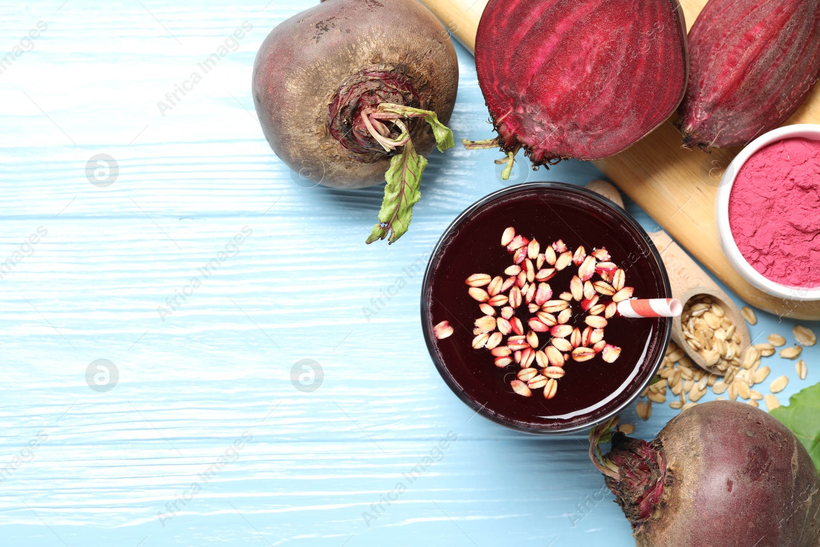Superfood. Tasty juice with oats in glass, powder and beetroots on light blue wooden table, flat lay. Space for text Photo of Superfood. Tasty juice with oats in glass, powder and beetroots on light blue wooden table, flat lay. Space for text
