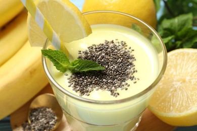 Photo of Superfood. Tasty smoothie with chia seeds in glass and ingredients on table, closeup