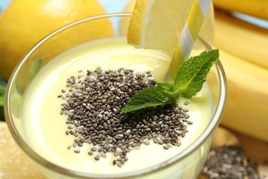 Photo of Superfood. Tasty smoothie with chia seeds in glass and ingredients on table, closeup