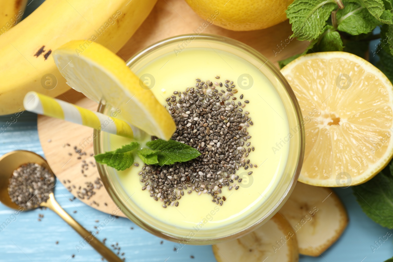 Superfood. Tasty smoothie with chia seeds in glass and ingredients on light blue wooden table, flat lay Photo of Superfood. Tasty smoothie with chia seeds in glass and ingredients on light blue wooden table, flat lay