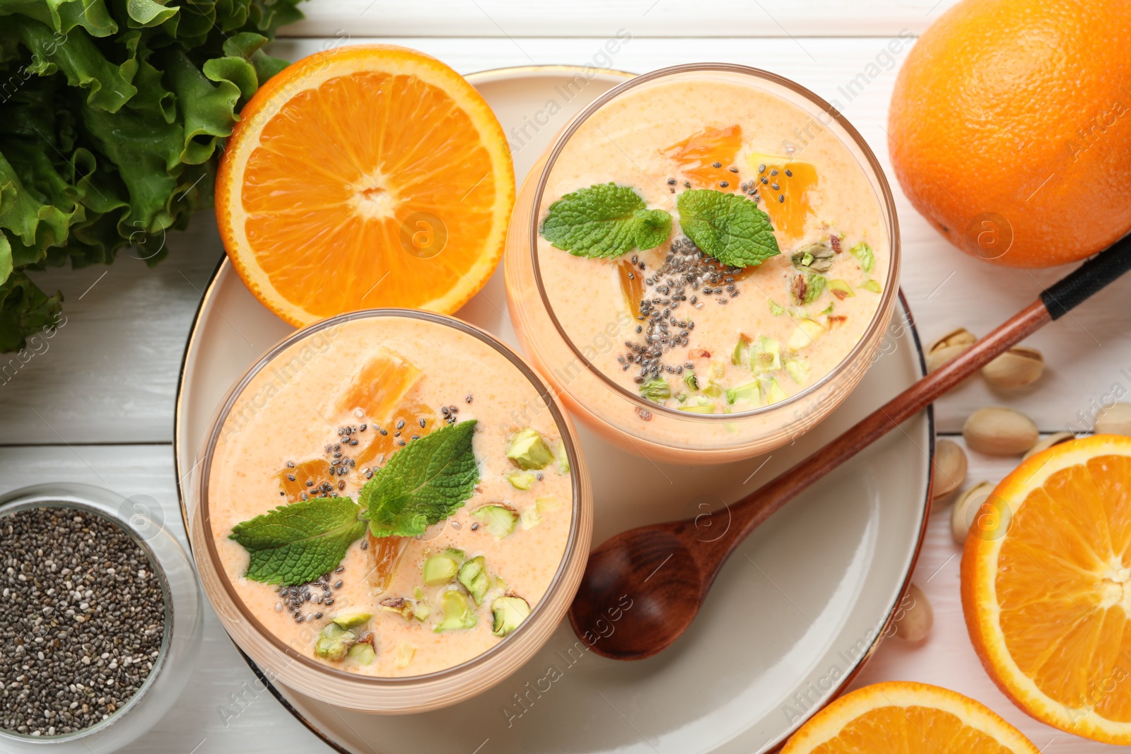 Superfood. Tasty smoothie with chia seeds, mint, pistachio and oranges on white wooden table, flat lay Photo of Superfood. Tasty smoothie with chia seeds, mint, pistachio and oranges on white wooden table, flat lay