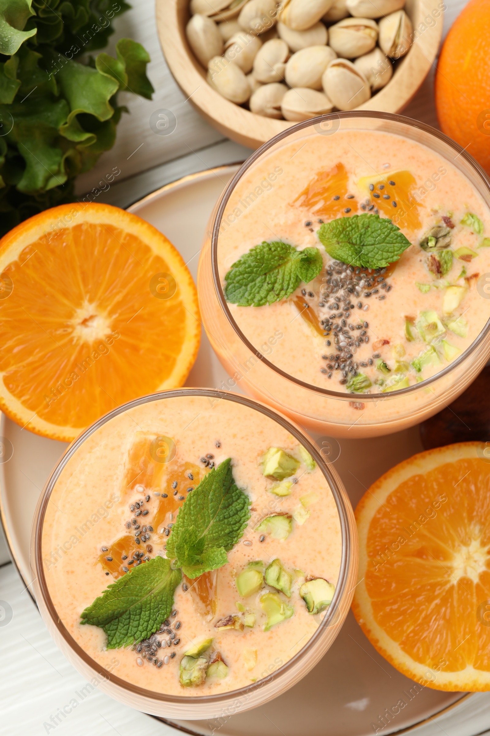 Superfood. Tasty smoothie with chia seeds, mint, pistachio and oranges on white wooden table, flat lay Photo of Superfood. Tasty smoothie with chia seeds, mint, pistachio and oranges on white wooden table, flat lay