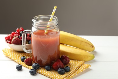 Photo of Superfood. Healthy drink in mason jar and ingredients on white wooden table against grey background, closeup