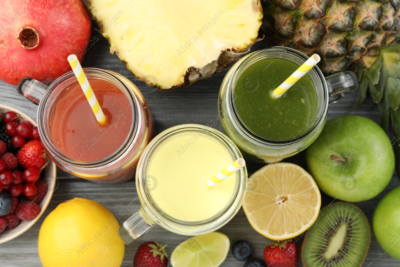 Superfood. Tasty smoothies in mason jars and ingredients on grey wooden table, flat lay Photo of Superfood. Tasty smoothies in mason jars and ingredients on grey wooden table, flat lay