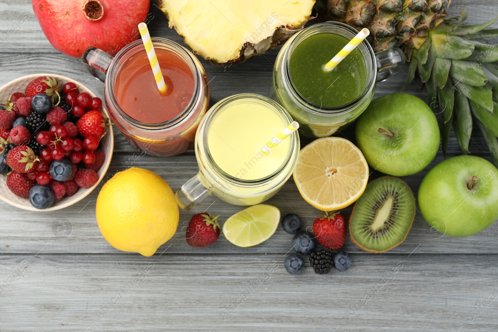 Superfood. Tasty smoothies in mason jars and ingredients on grey wooden table, flat lay Photo of Superfood. Tasty smoothies in mason jars and ingredients on grey wooden table, flat lay
