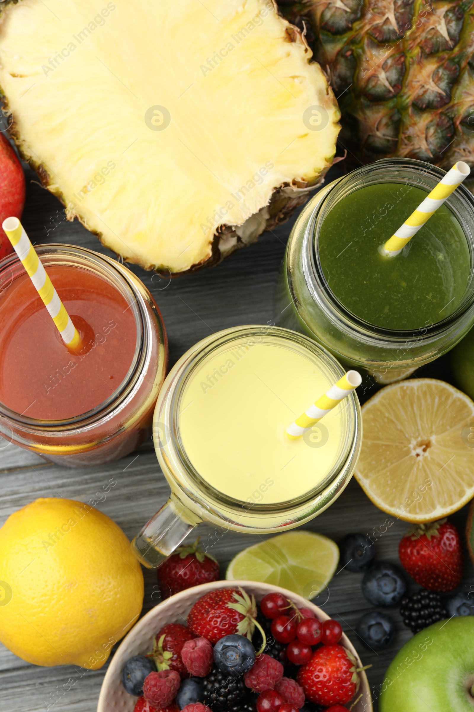 Superfood. Tasty smoothies in mason jars and ingredients on grey wooden table, flat lay Photo of Superfood. Tasty smoothies in mason jars and ingredients on grey wooden table, flat lay