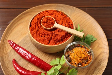 Photo of Different aromatic spices on wooden table, closeup