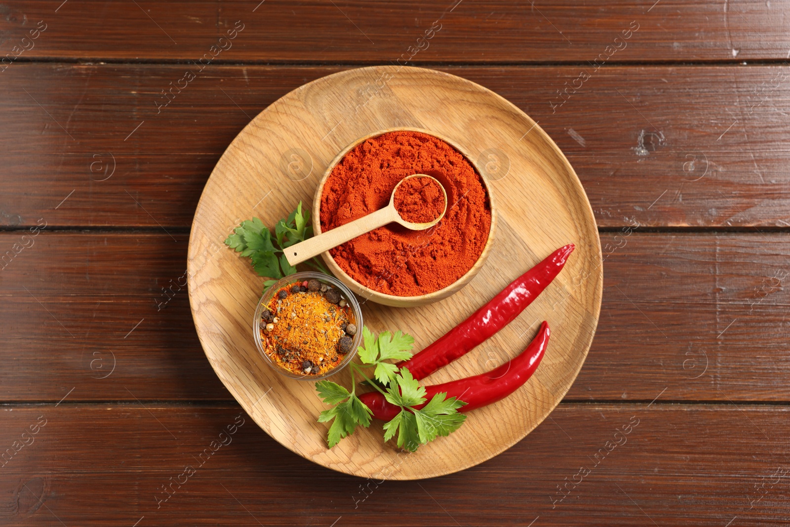 Photo of Different aromatic spices on wooden table, top view