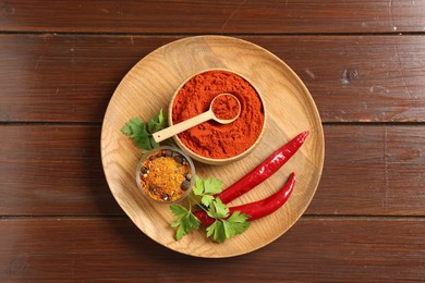 Photo of Different aromatic spices on wooden table, top view